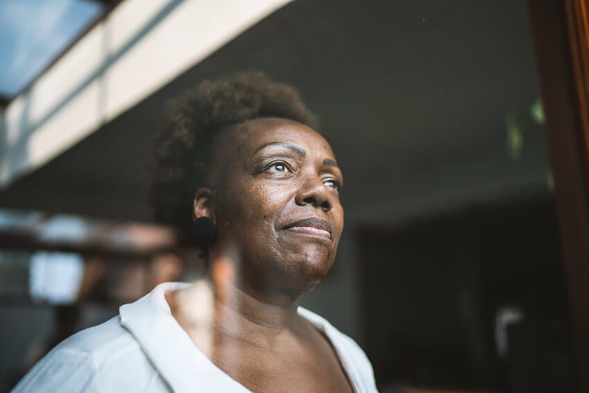 Senior woman looking through the window