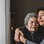 Older woman in wheelchair hugging daughter.