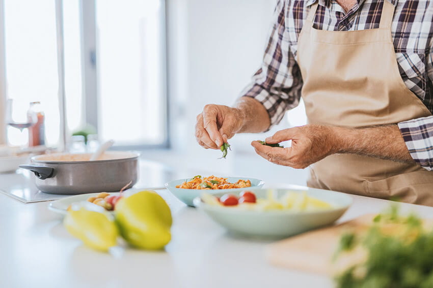 Man preparing a healthy salad at home.