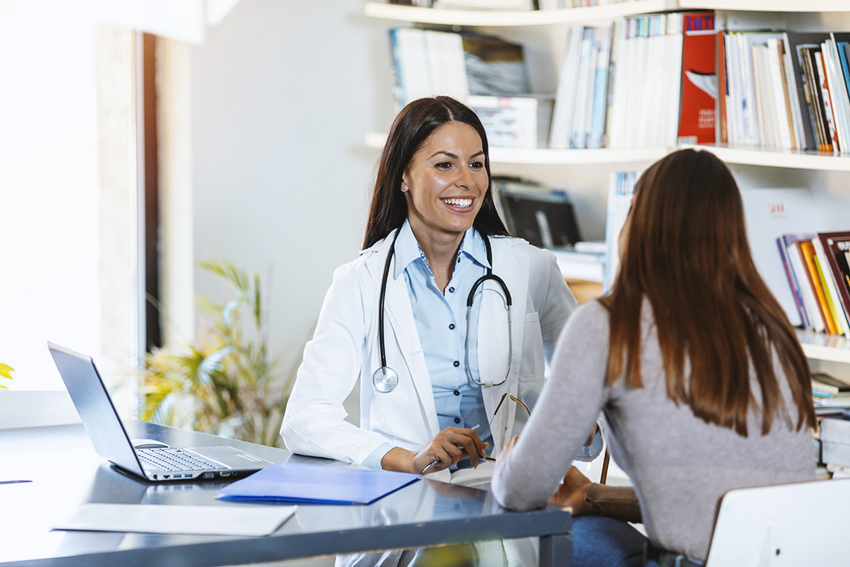 Female adult gynaecologist working with patient in clinic.