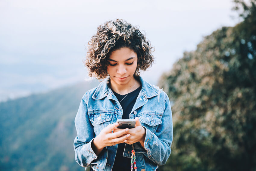 Teenage girl on cellphone outdoors.