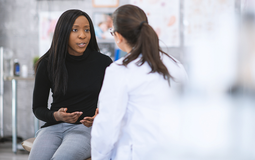 Woman speaking with her OB/GYN in a doctor's office.