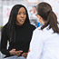 Woman speaking with her OB/GYN in a doctor's office.