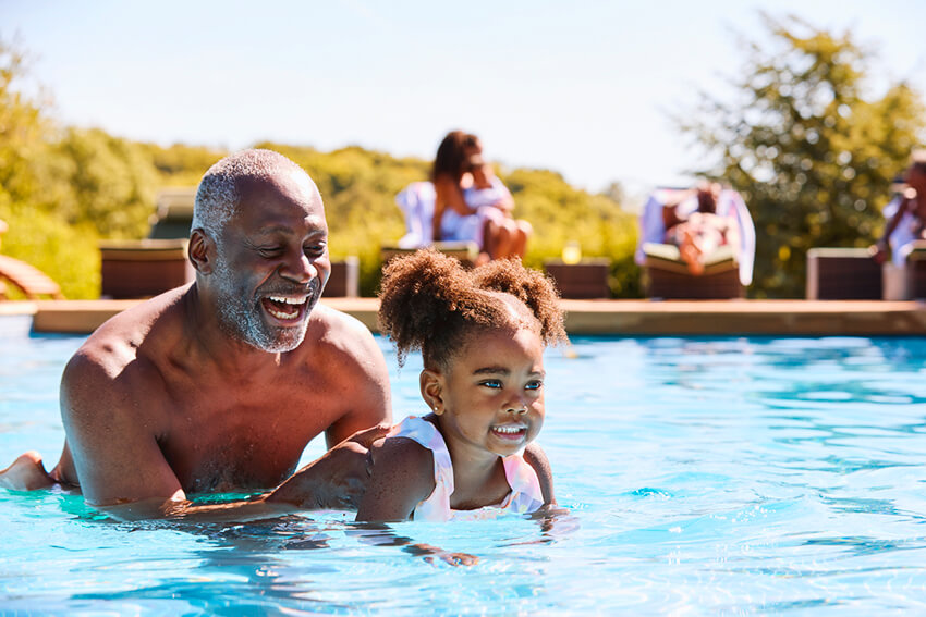 Father carries doubter in pool.