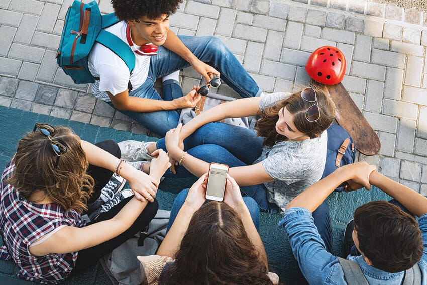 Group of teenage friends laughing and talking after school.