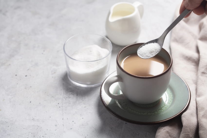 Mixing sweetener into coffee.