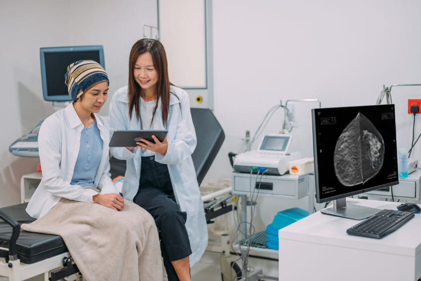 A doctor showing test results on an electronic wireless tablet to her patient.