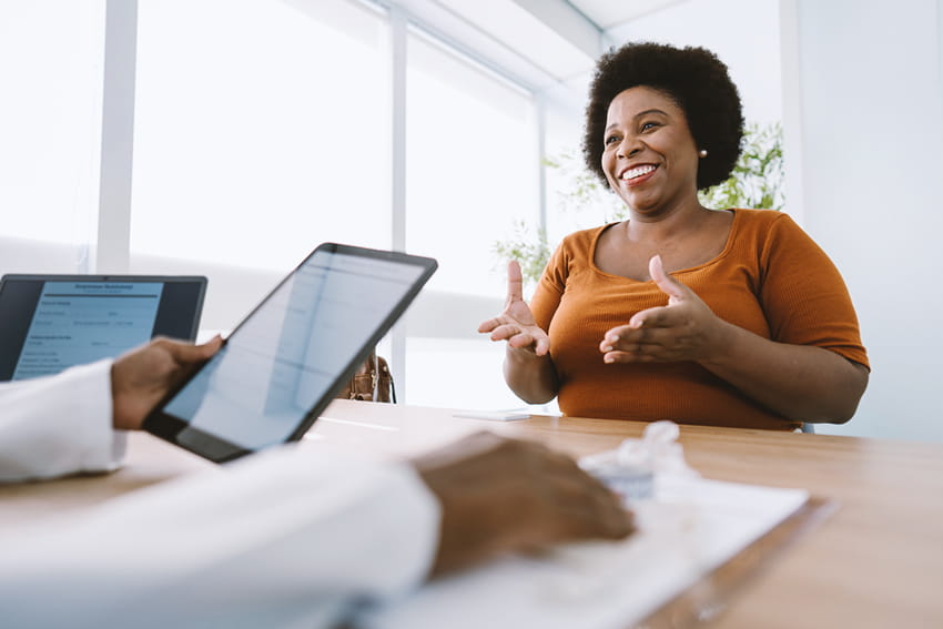 Woman speaking with a doctor in an office.