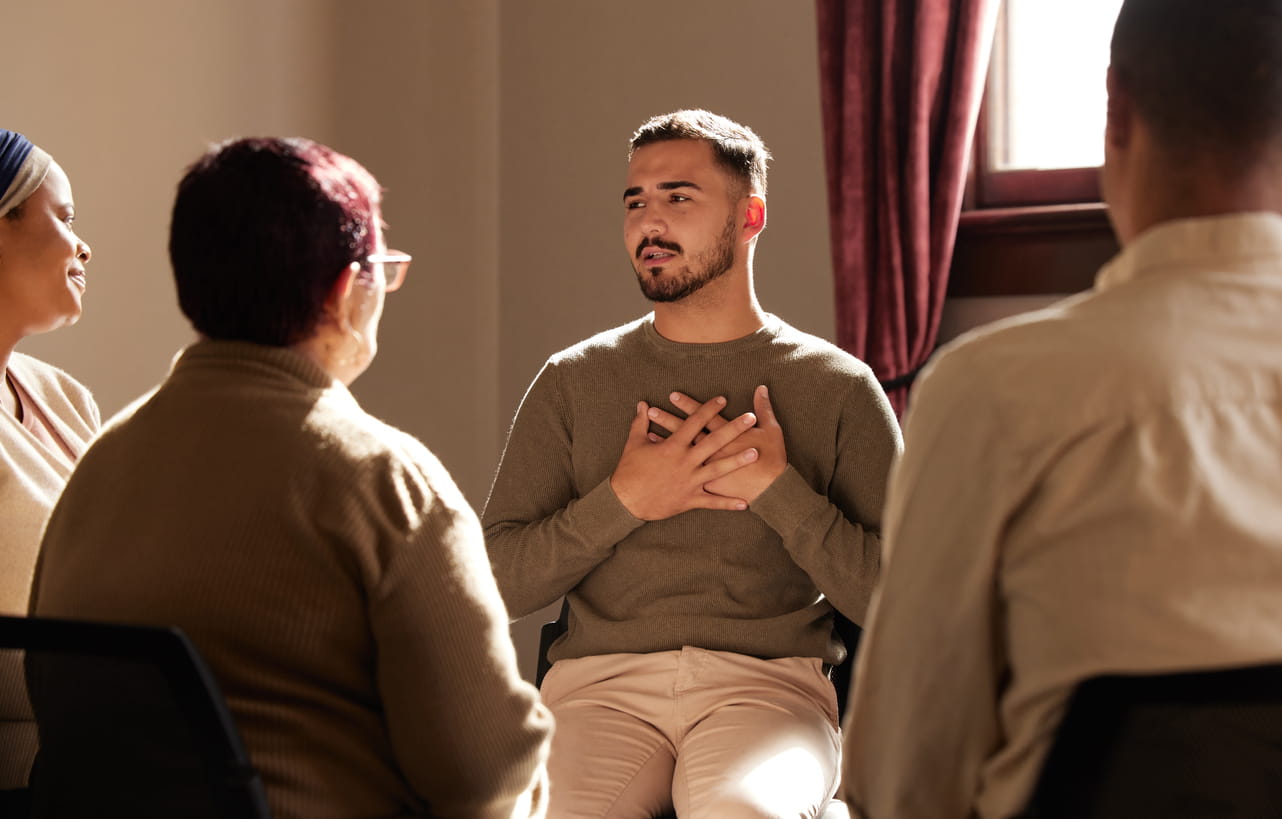 A man speaking in group therapy.