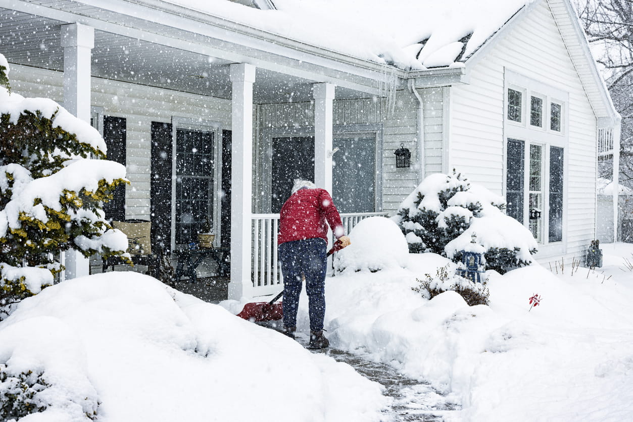 Woman shoveling snow on walkway