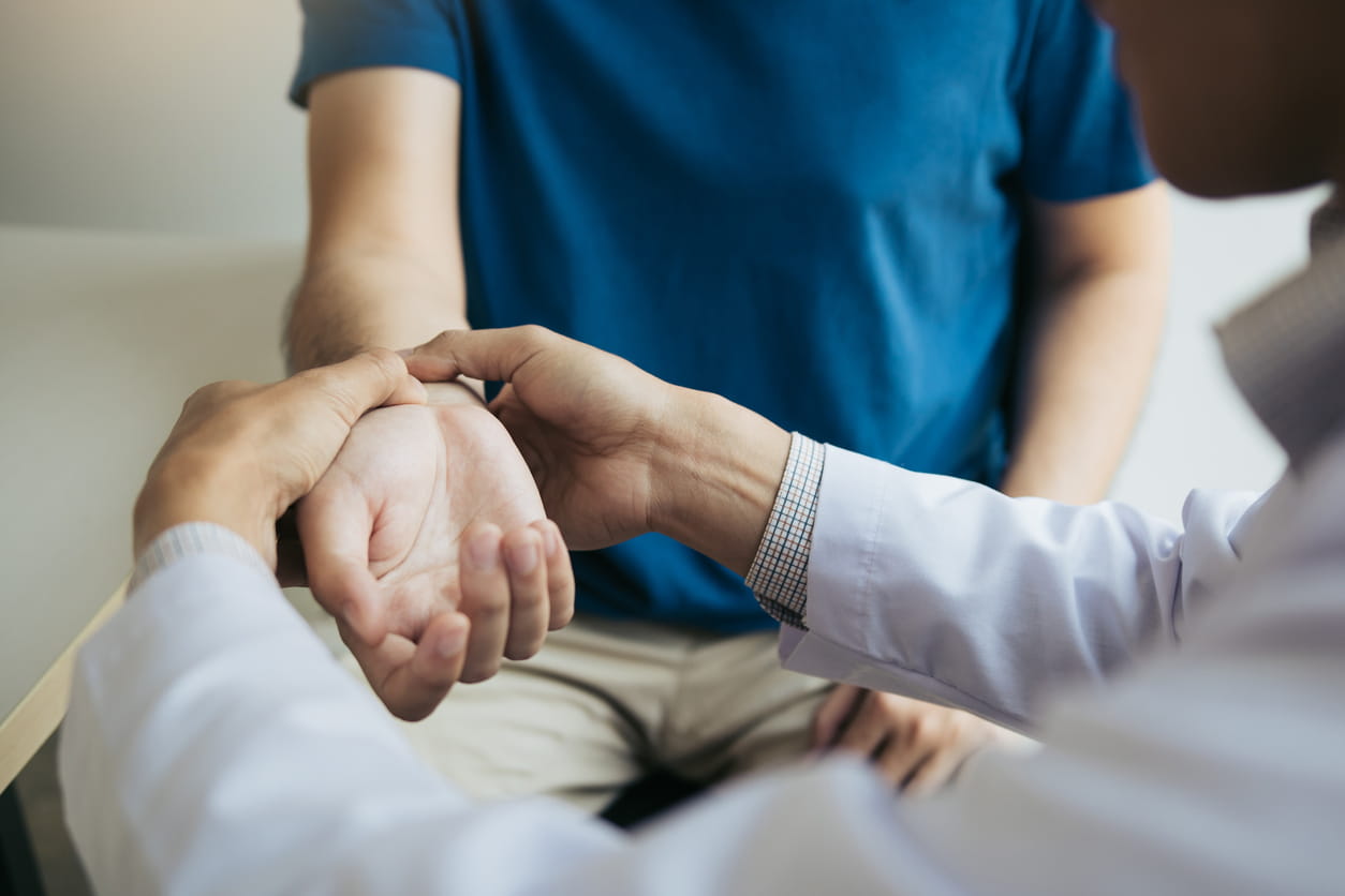 Doctor checks the patient wrist by pressing the wrist bone in clinic room.