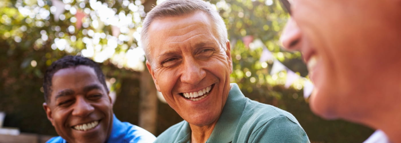 Three men laughing together outside.