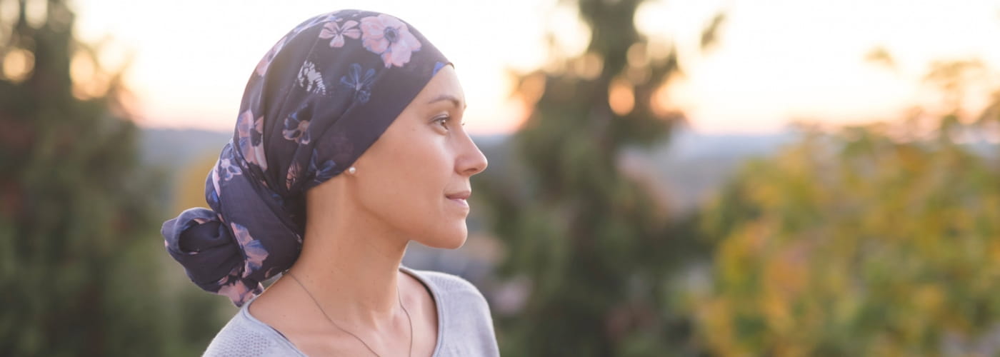 Woman battling cancer stands outside