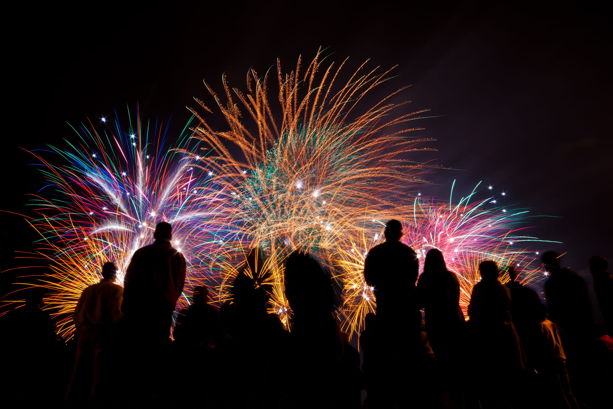 fireworks with silhouetted people in the foreground watching