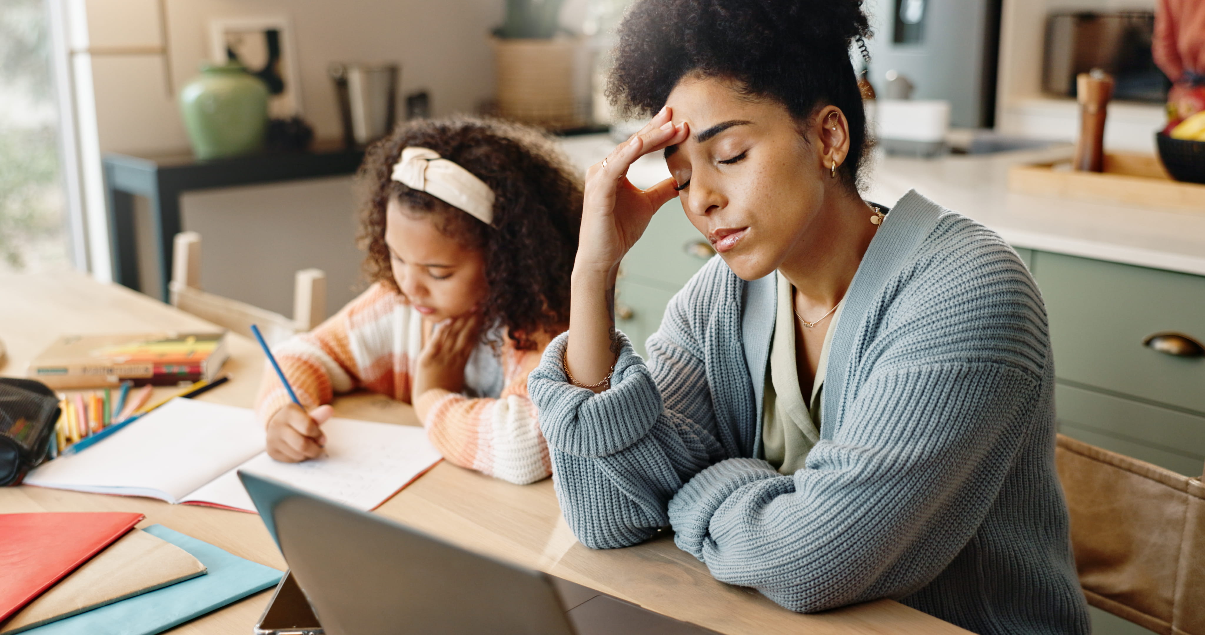Mother looking stressed while child does homework