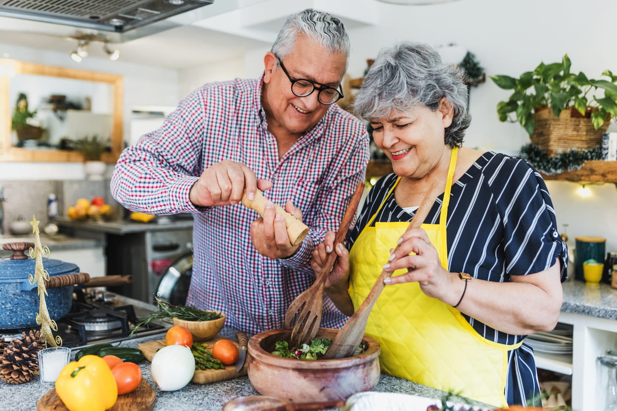 Older couple making a salad at home