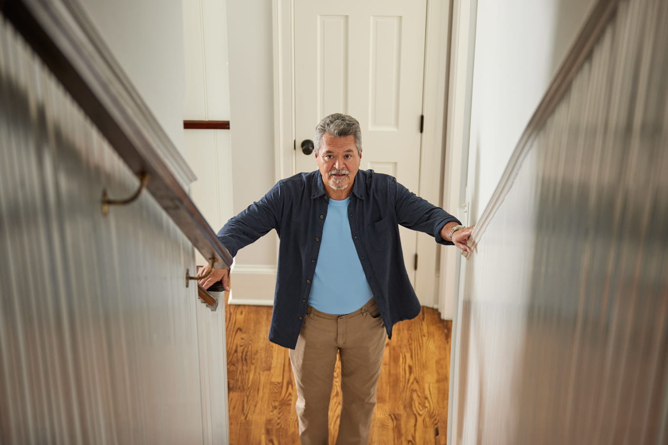 Man holding railings going up stairs
