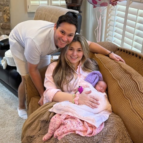 Robyn Rubenstein holding baby Bella on the couch with Evan next to her