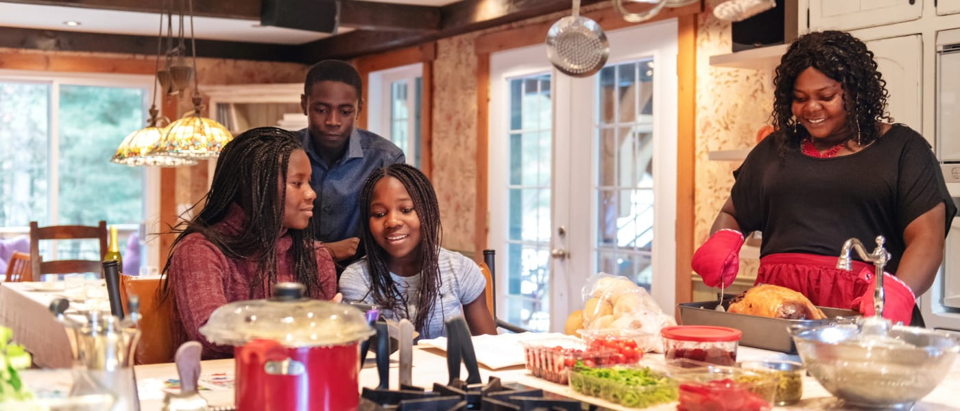 mother and three teens preparing Thanksgiving dinner