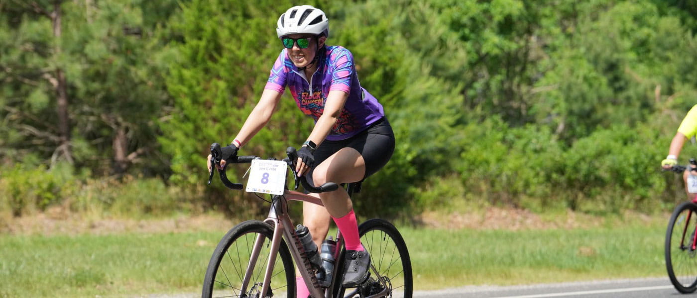 Emily Levy, MD, biking with her race number on her handlebars for the American Cancer Society Bike-A-Thon.
