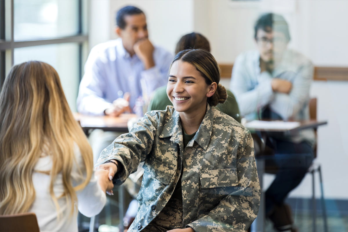 Recruiter shaking hands with female military soldier