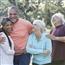 Group of five multi-ethnic seniors standing in park