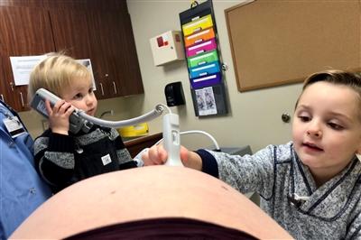 Kathleens young son listening to babys heartbeat at doctors appointment