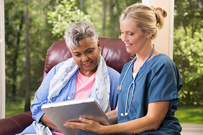 Health care provider and patient sitting looking at documents on a clipboard