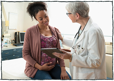 Pregnant woman sitting and talking with doctor