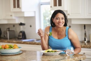 woman eating healthy meal in kitchen
